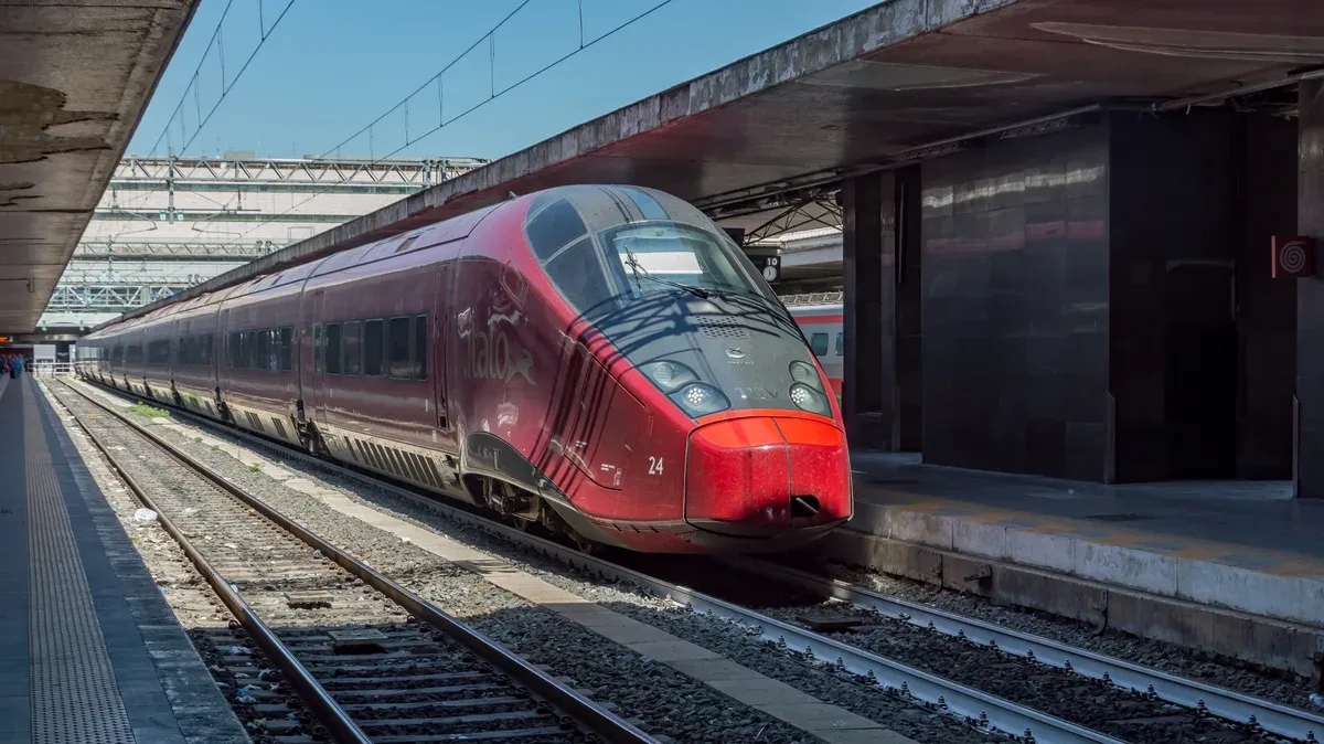 A red Italo high-speed train at a platform in Roma Termini, seen on the Rome to Florence train