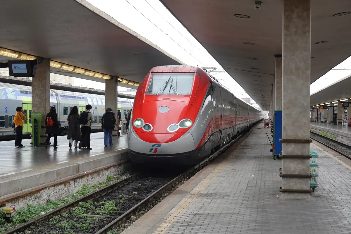 A red Frecciarossa high-speed train at a platform in Florence Santa Maria Novella station, the arrival point of train tours from Rome to Florence